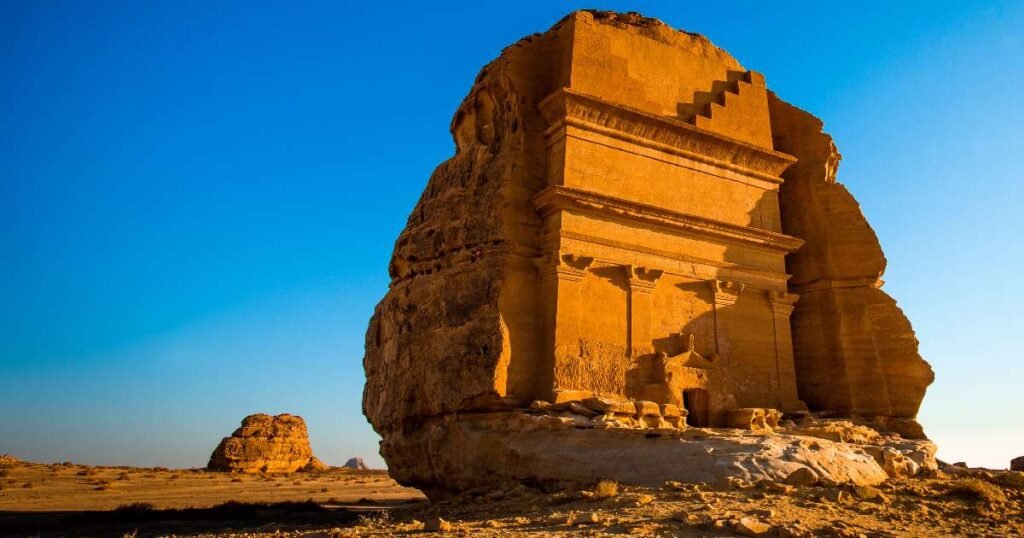 "The carved rock tombs of Hegra in Al-Ula with the desert landscape in the background."