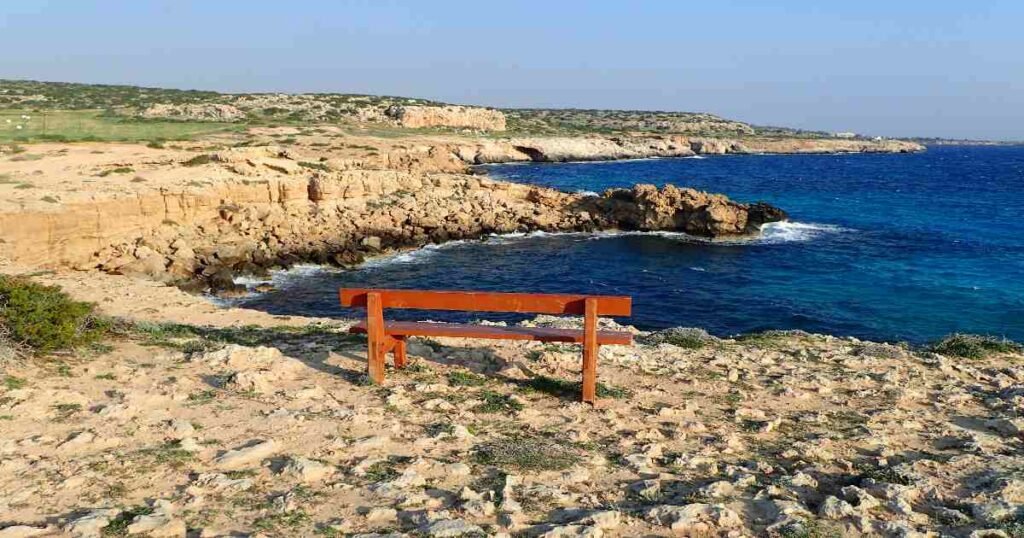 "The sea caves at Cape Greco with turquoise waters crashing against the rocky cliffs."