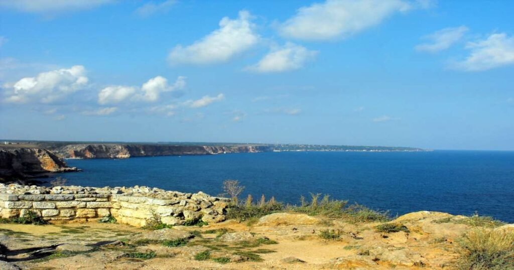 “Red cliffs of Cape Kaliakra overlooking the Black Sea under a clear blue sky.”