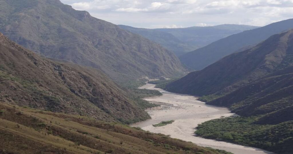 “Breathtaking view of Chicamocha Canyon with steep cliffs and winding river below.”