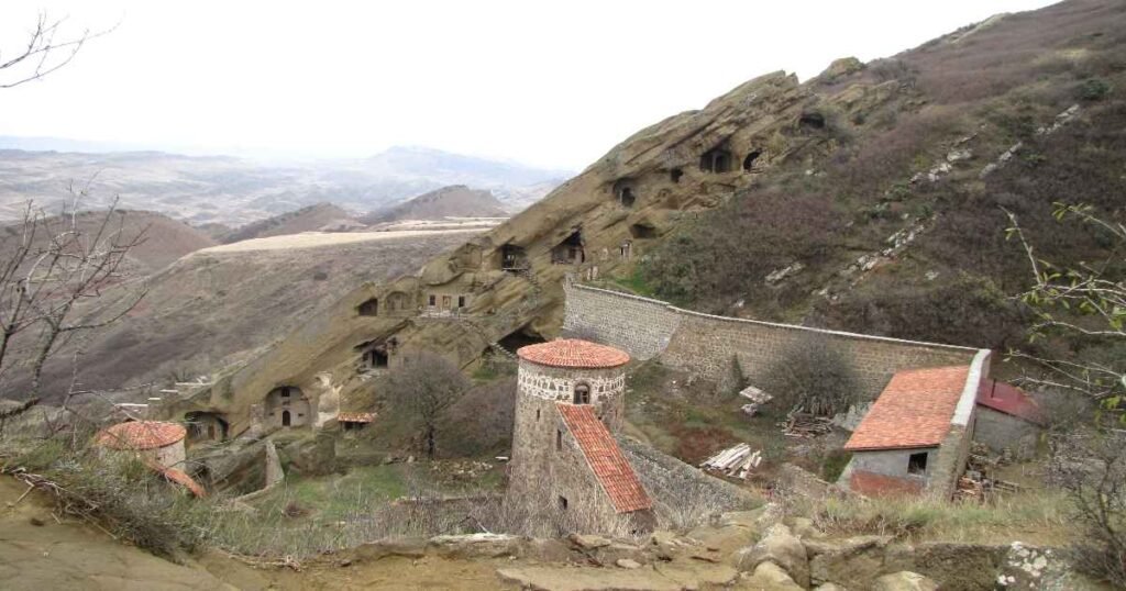 "The David Gareja Monastery Complex carved into rocky hills, overlooking vast landscapes."