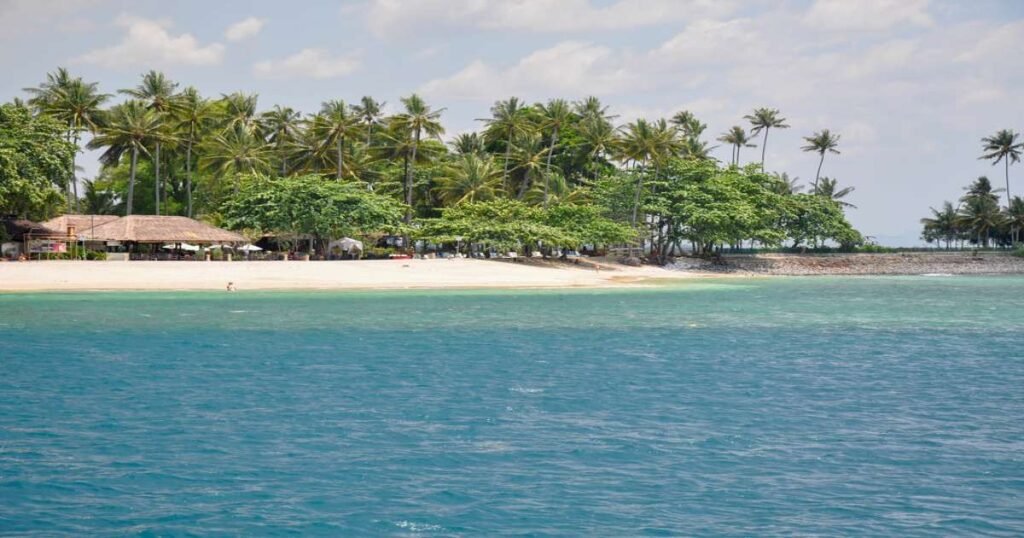 “Crystal-clear waters and a white sandy beach on Gili Trawangan with palm trees swaying in the breeze.”