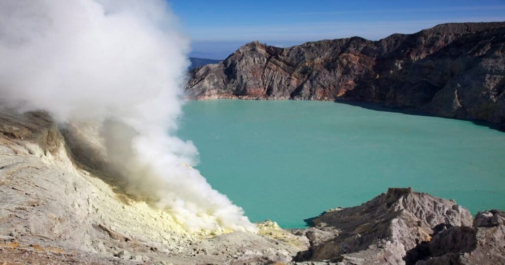 “Turquoise-colored Ijen Crater Lake surrounded by rugged cliffs.”