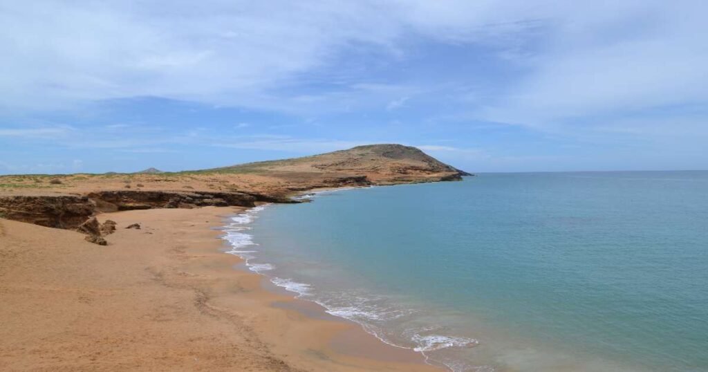 “Golden sand dunes of La Guajira Peninsula meeting the blue Caribbean Sea.”