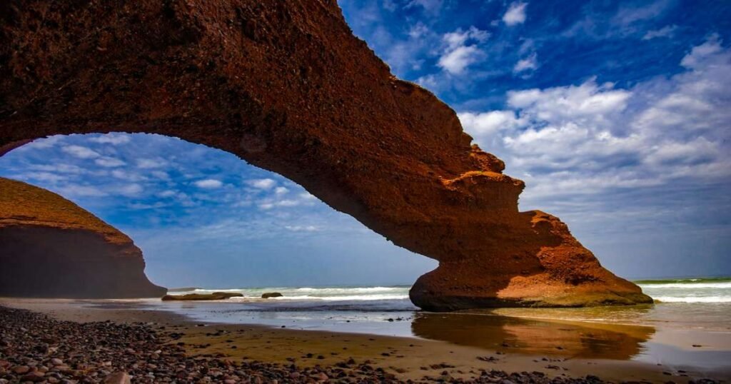“Massive natural rock arches on Lagzira Beach with waves crashing along the Atlantic coast.”