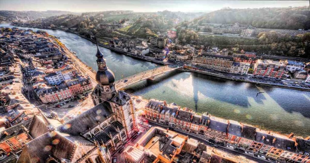 "The scenic Meuse Valley with the river winding through lush greenery, quaint towns, and historic castles."