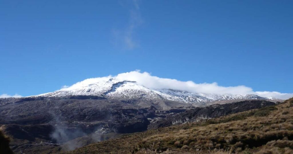 “Snow-covered peak of Nevado del Ruiz with the rugged Andean landscape below.”