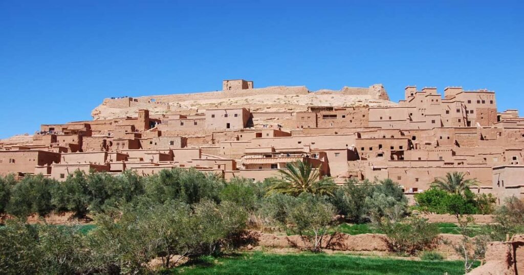 "The ancient clay kasbah of Taourirt in Ouarzazate under a clear blue sky."