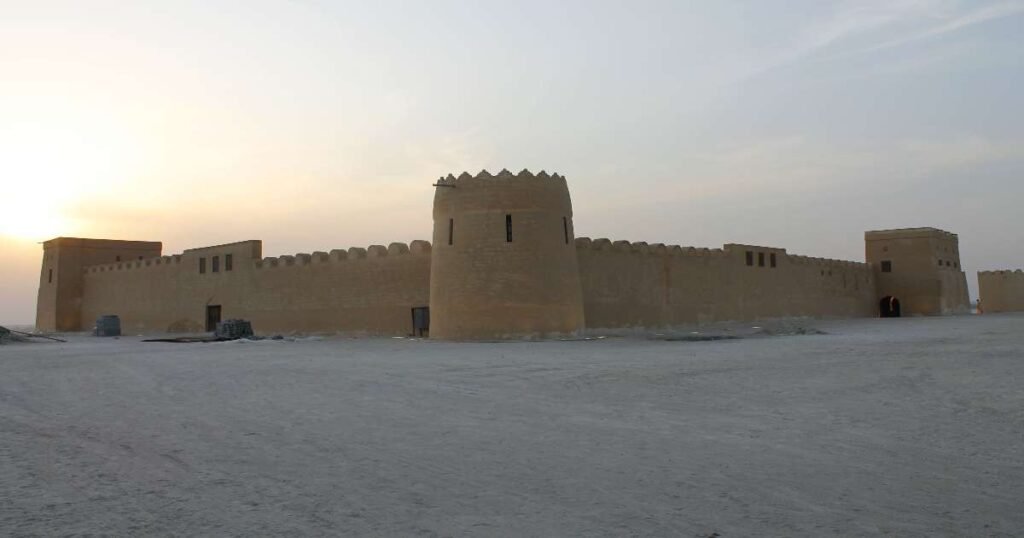 Historical Riffa Fort with sand-colored walls and view of Hunanaiya Valley in Bahrain.