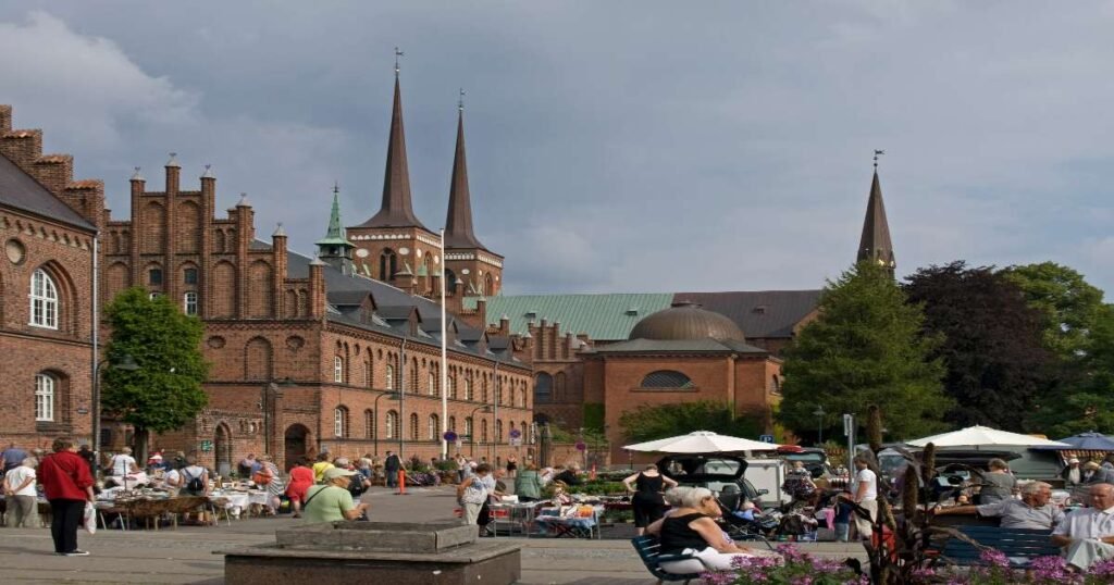 "Exterior view of Roskilde Cathedral and its twin spires against the sky."