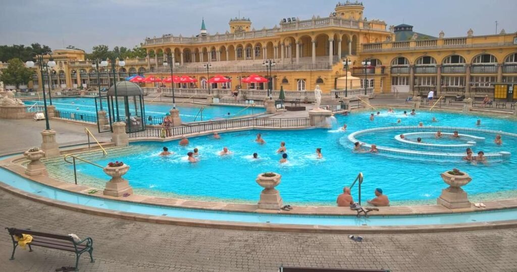  Outdoor thermal pools at Széchenyi Bath with iconic yellow architecture in Budapest.