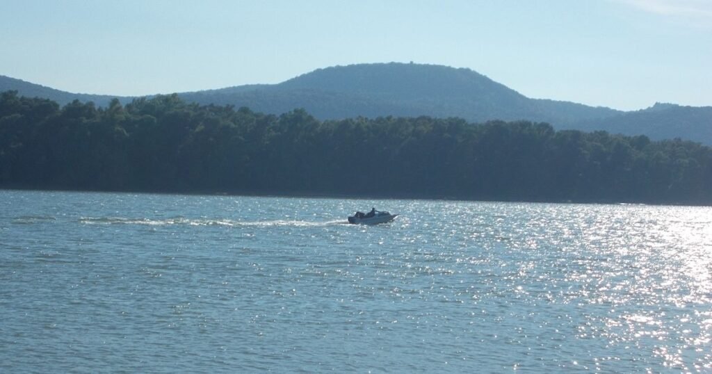 “Canoers paddling along the calm waters surrounding Szentendre Island with lush green banks.”