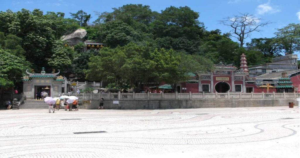 "A-Ma Temple nestled among greenery, with intricate stone carvings and temple structures."