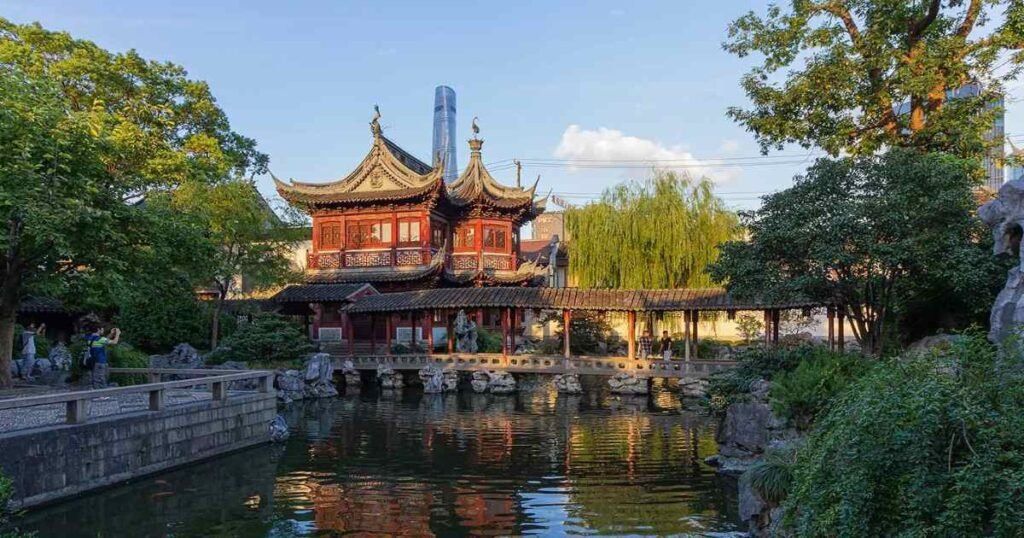 A traditional Chinese pavilion surrounded by water and greenery in Suzhou’s gardens.