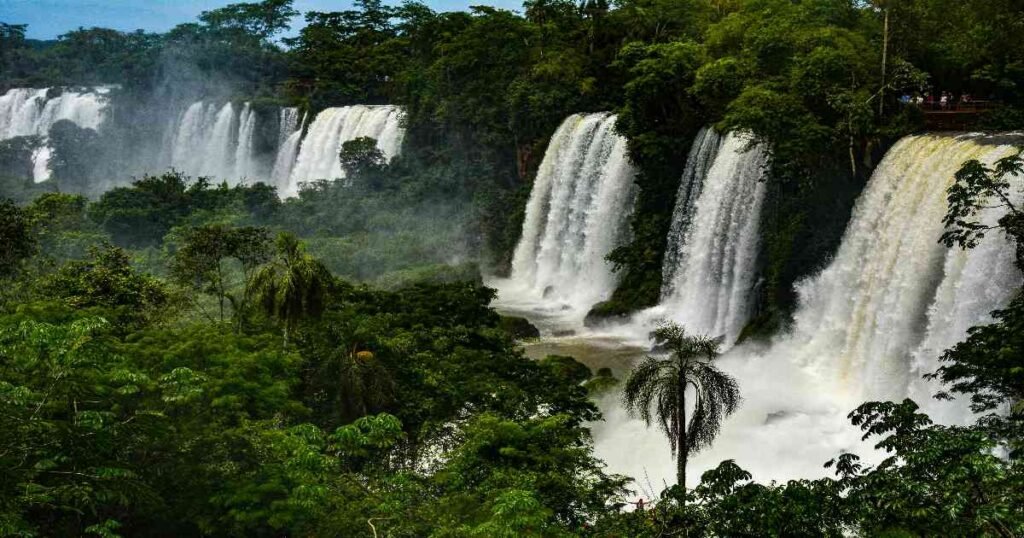 "A panoramic view of Iguazu Falls with cascading water and lush greenery."