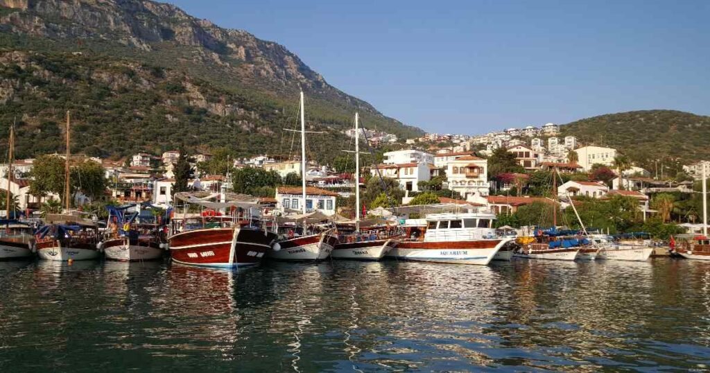 Kaş’s marina with turquoise waters and yachts surrounded by lush hills.