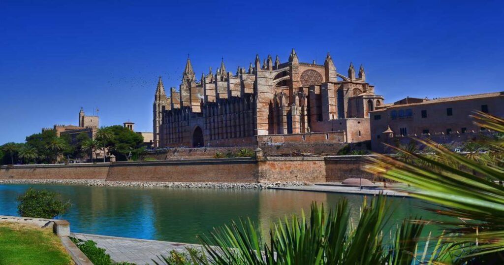 La Seu Cathedral in Palma de Mallorca glowing at sunset near the waterfront.