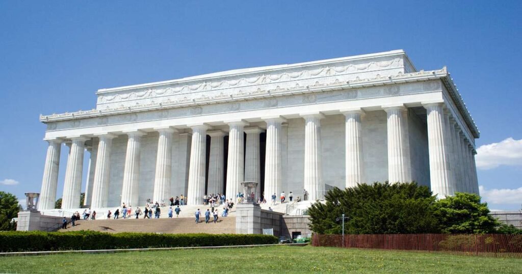 “Lincoln Memorial’s towering columns framing the seated statue of Abraham Lincoln,”