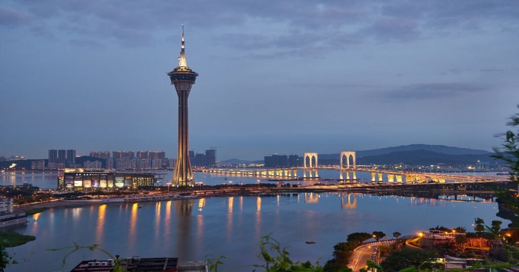 "The towering Macau Tower against the city skyline, with clear blue skies in the background."