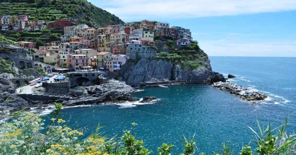 Colorful houses perched on a cliff in Manarola, Cinque Terre, overlooking the sea.