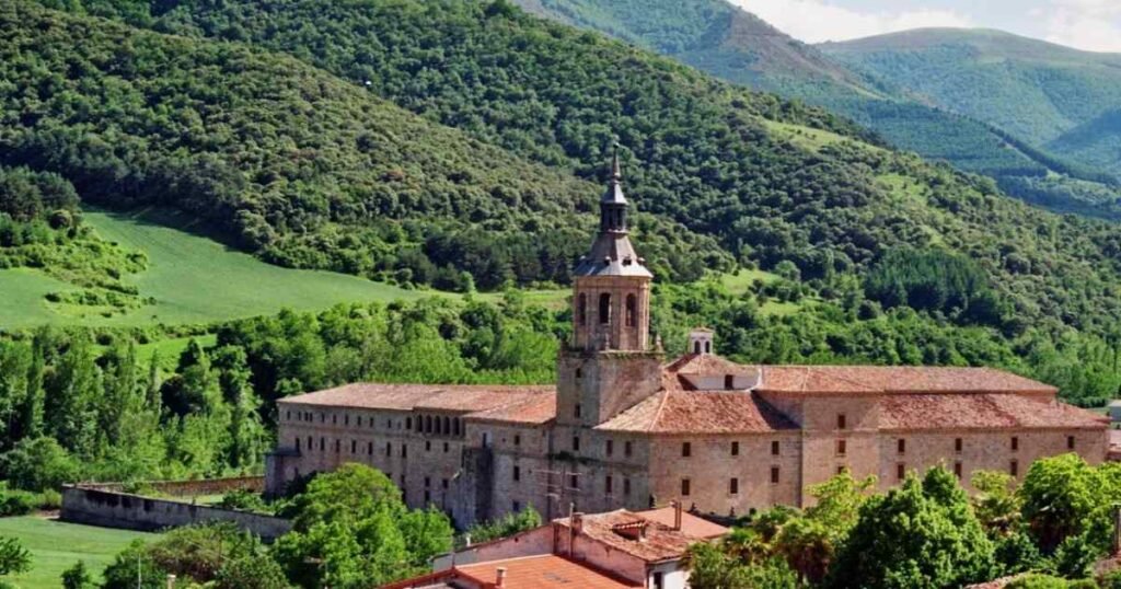 Panoramic views of the monasteries of San Millán de la Cogolla surrounded by lush greenery.