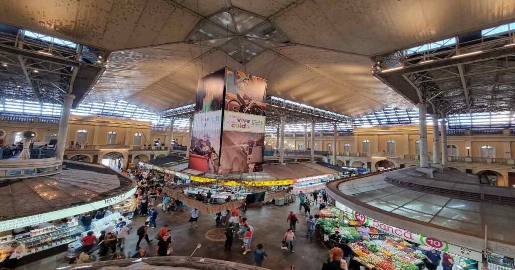  "Busy stalls and shoppers inside Porto Alegre’s Mercado Público."