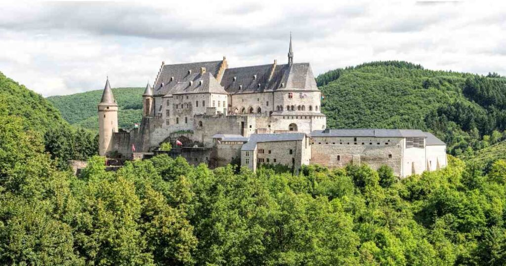 "Vianden Castle atop a green hill with stunning architectural features."
