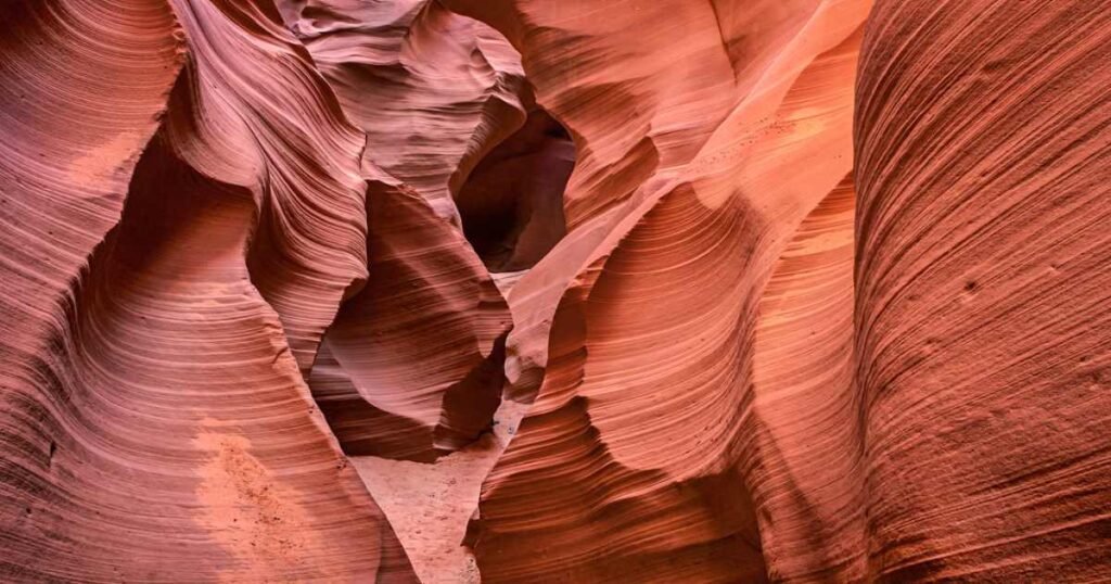 The sun shining through the narrow walls of Antelope Canyon, creating vibrant orange hues.