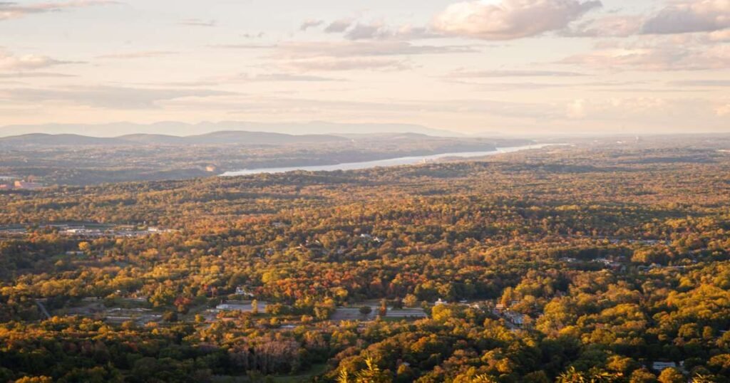 A scenic view of the Hudson River framed by colorful fall foliage.