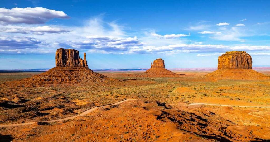 Towering sandstone formations in Monument Valley under a clear blue sky.