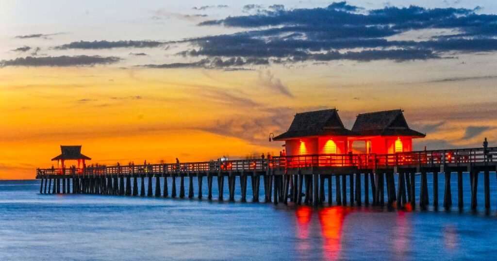 Naples Pier stretching into the Gulf of Mexico with calm waves.