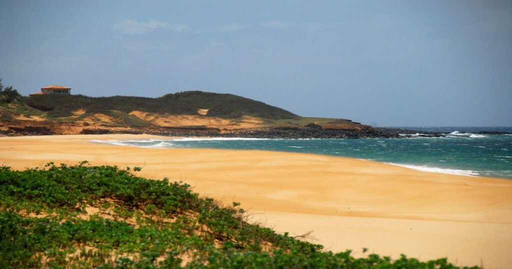 Panoramic view of Papohaku Beach with its long stretch of white sand and turquoise waters.