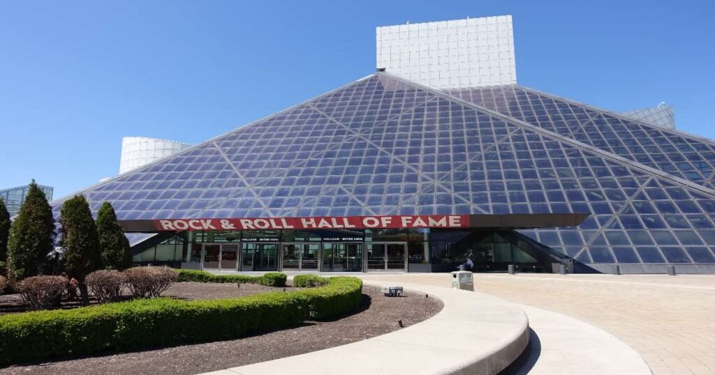 The iconic Rock and Roll Hall of Fame building under the bright sky.