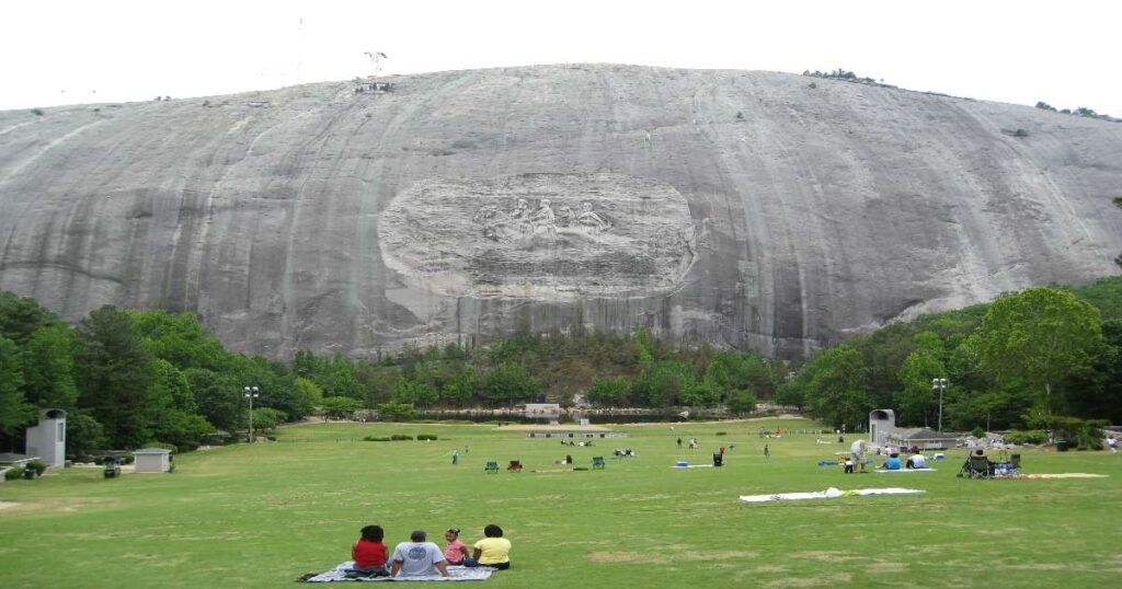 A view of Stone Mountain with lush green trees in the foreground.