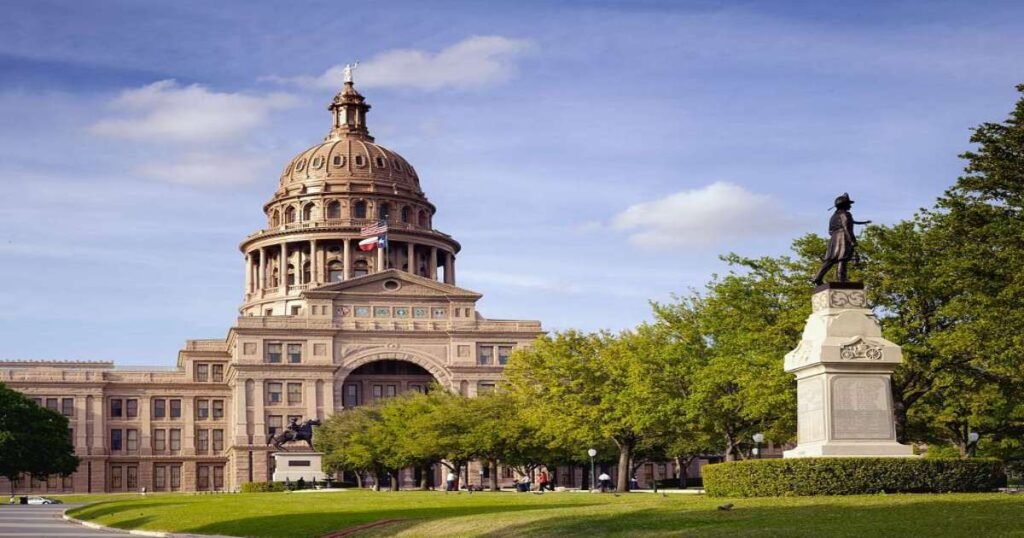 The Texas State Capitol building surrounded by vibrant greenery in Austin.