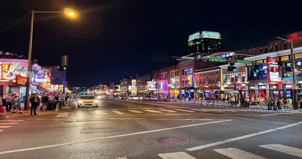 The neon-lit Broadway Street in Nashville bustling with music lovers.