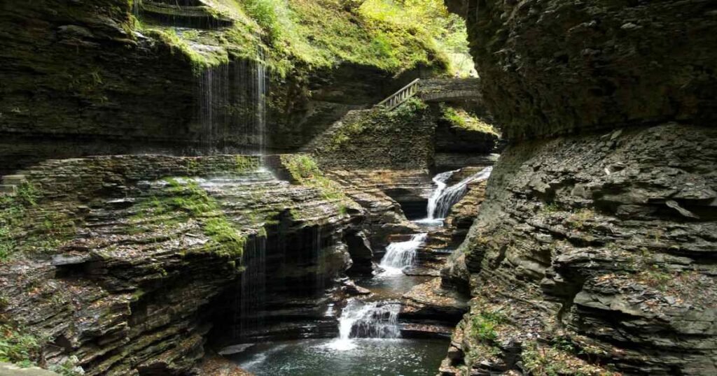 A cascading waterfall surrounded by lush greenery in Watkins Glen State Park.