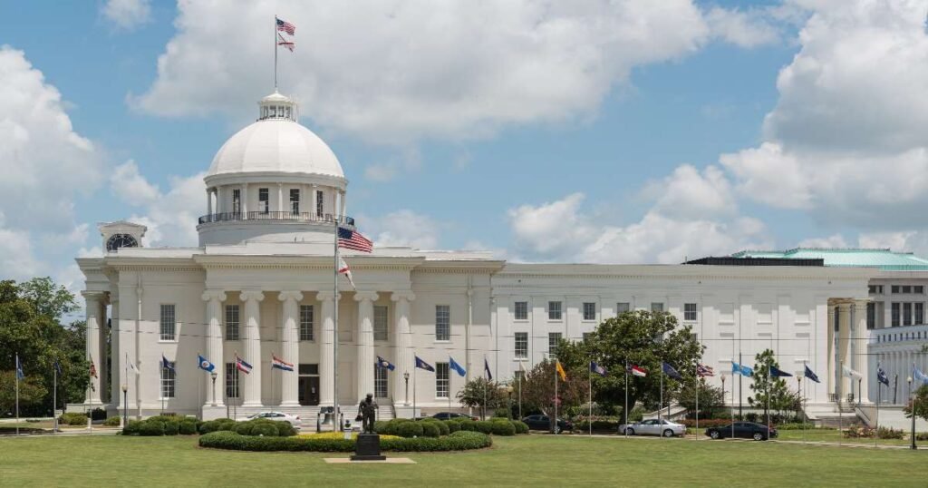 The historic Alabama State Capitol building under a bright blue sky.